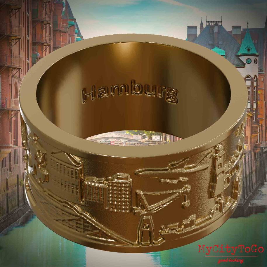 Ring aus vergoldetem Edelstahl mit Reliefs bekannter Sehenswürdigkeiten der Stadt Hamburg und einer Gravur des Stadtnamens auf der Innenseite. Den Hintergrund bildet eine Ansicht der Stadt Hamburg.