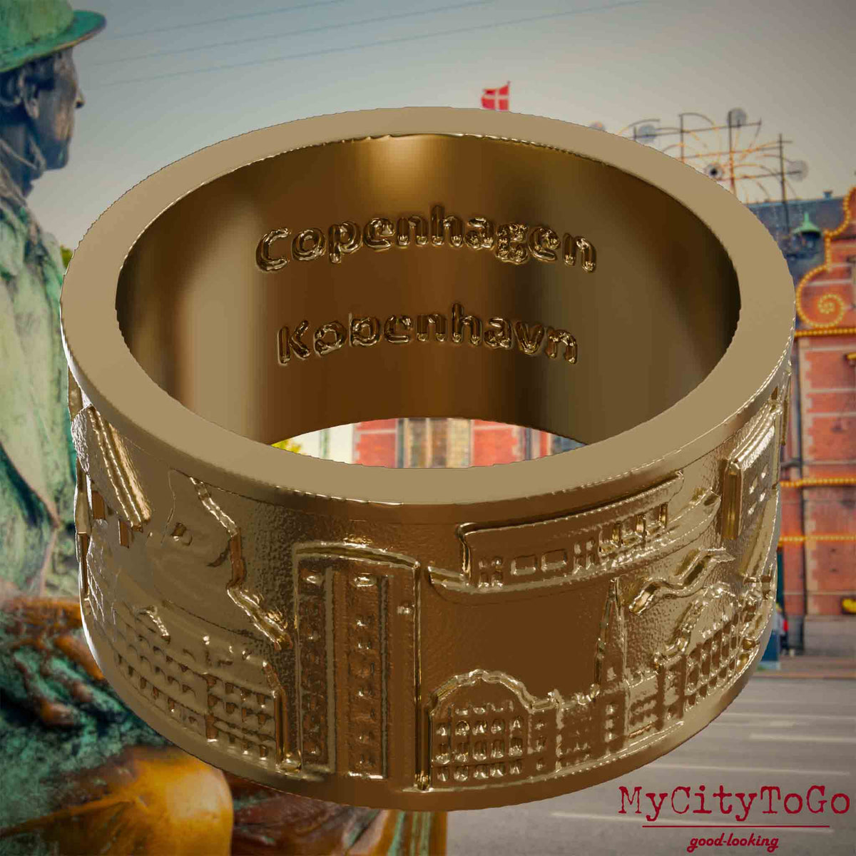 Ring aus vergoldetem Edelstahl mit Reliefs bekannter Sehenswürdigkeiten der Stadt Kopenhagen und einer Gravur des Stadtnamens auf der Innenseite. Den Hintergrund bildet eine 
Ansicht der Stadt Kopenhagen.