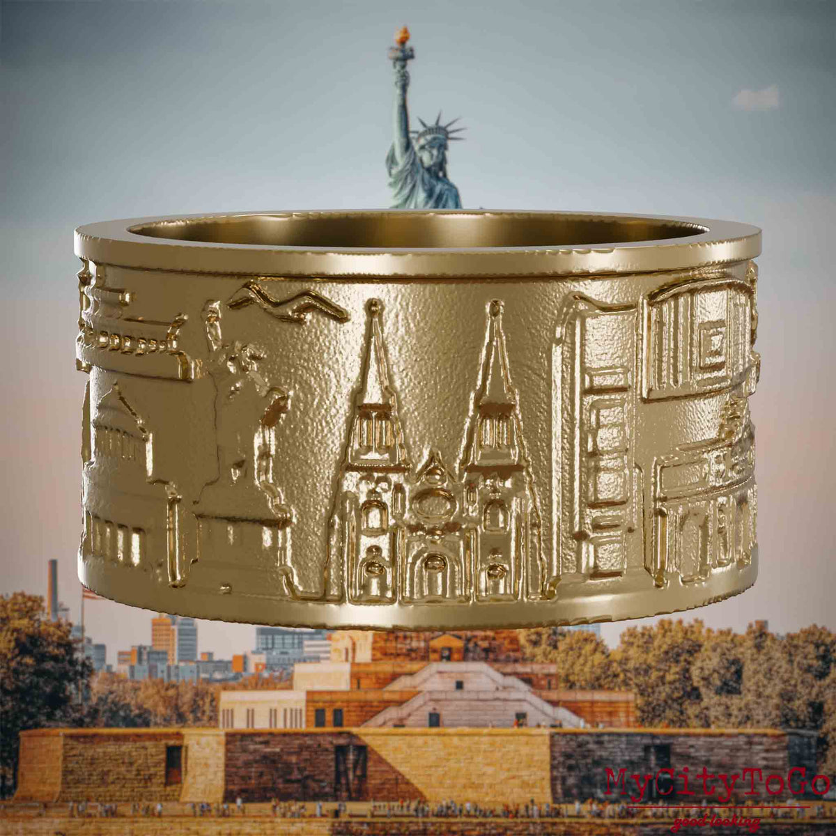 Ring aus vergoldetem Edelstahl mit Reliefs bekannter Sehenswürdigkeiten der Stadt New York. Den Hintergrund bildet eine Ansicht der Stadt New York.