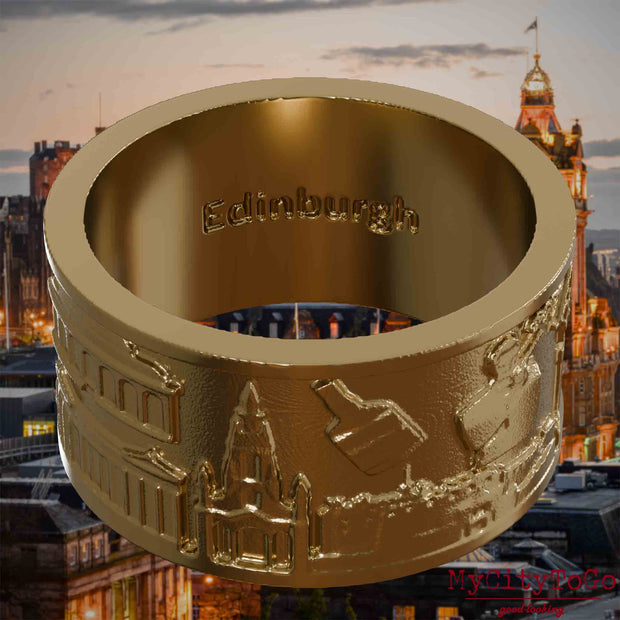 Ring aus vergoldetem Edelstahl mit Reliefs bekannter Sehenswürdigkeiten der Stadt Edinburgh und einer Gravur des Stadtnamens auf der Innenseite. Den Hintergrund bildet eine Ansicht der Stadt Edinburgh.
