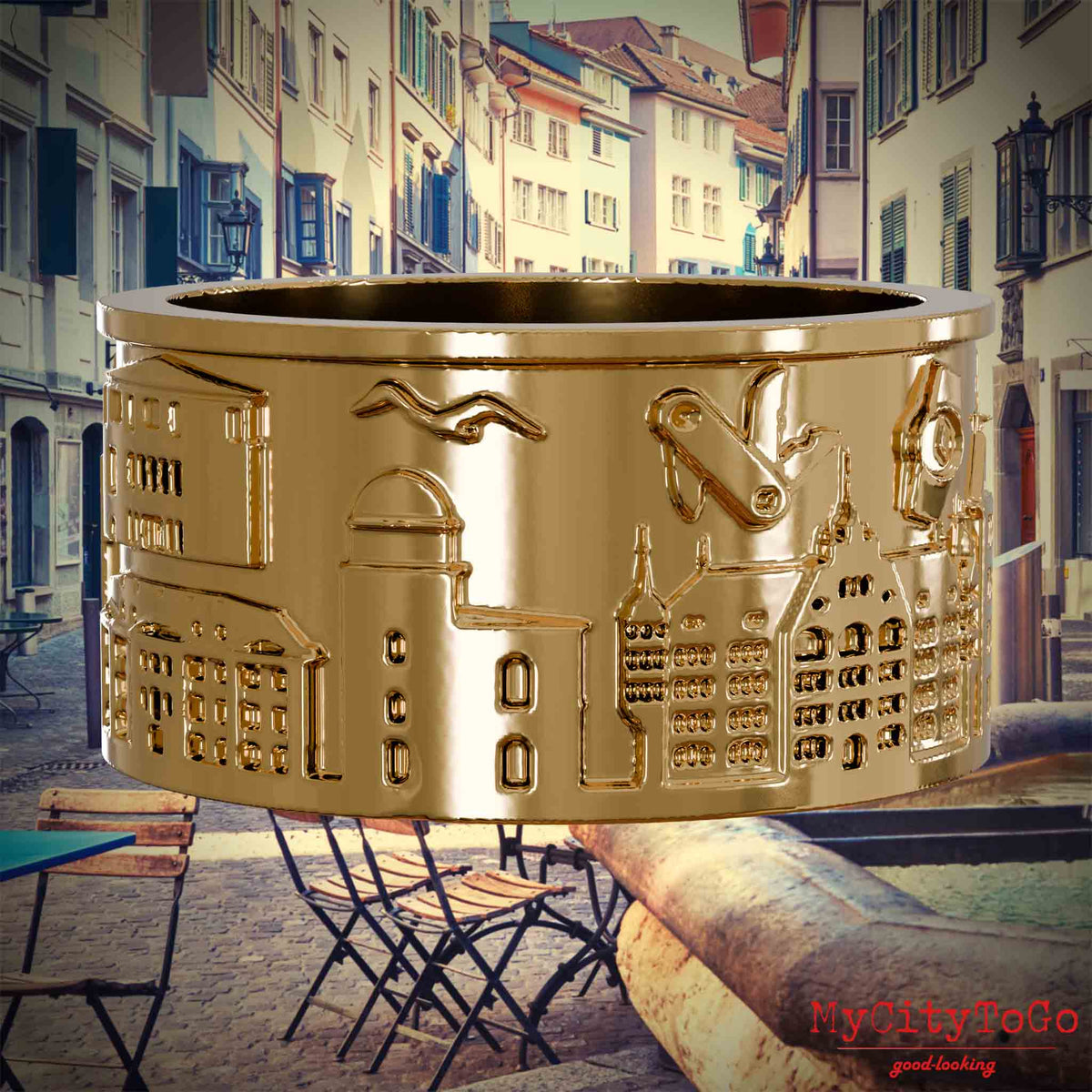 Vergoldeter Ring mit Reliefs bekannter Sehenswürdigkeiten der Stadt Zuerich. Den Hintergrund bildet eine Ansicht der Stadt Zuerich.