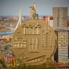 Halskette mit Drehwirbel und Vorderseite eines vergoldeten Schmuckanhängers, auf dem Reliefs bekannter Sehenswürdigkeiten der Stadt Rotterdam abgebildet sind. Den Hintergrund bildet eine Ansicht der Stadt Rotterdam.
