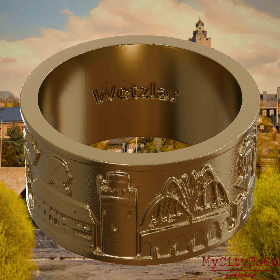 Ring aus vergoldetem Edelstahl mit Reliefs bekannter Sehenswürdigkeiten der Stadt Wetzlar und einer Gravur des Stadtnamens auf der Innenseite. Den Hintergrund bildet eine Ansicht der Stadt Wetzlar.