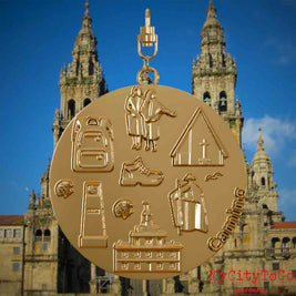 Halskette mit Drehwirbel und Vorderseite eines vergoldeten Schmuckanhängers, auf dem Reliefs bekannter Sehenswürdigkeiten des Jakobwegs abgebildet sind. Den Hintergrund bildet eine Ansicht der Stadt Santiago de Compostela.

