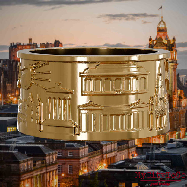 Vergoldeter Ring mit Reliefs bekannter Sehenswürdigkeiten der Stadt Edinburgh. Den Hintergrund bildet eine Ansicht der Stadt Edinburgh.