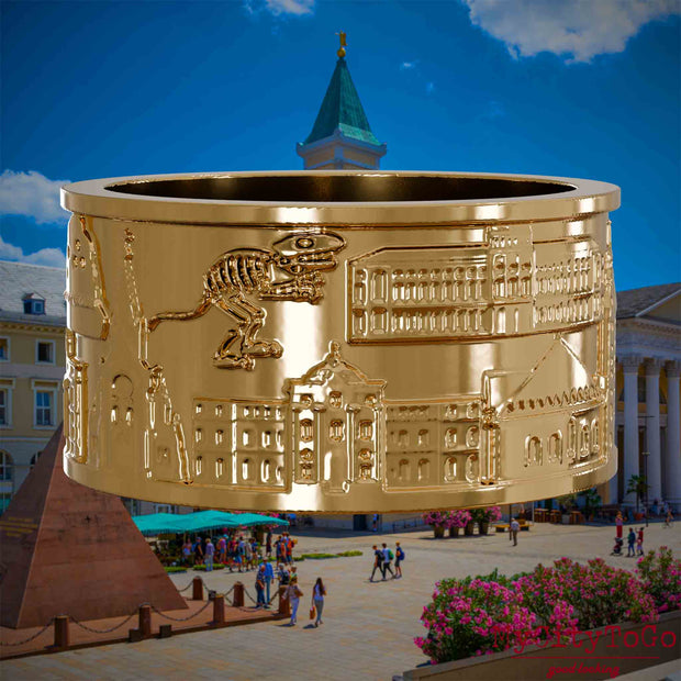 Vergoldeter Ring mit Reliefs verschiedener Motive der Stadt Karlsruhe. Den Hintergrund bildet eine Ansicht der Stadt Karlsruhe.