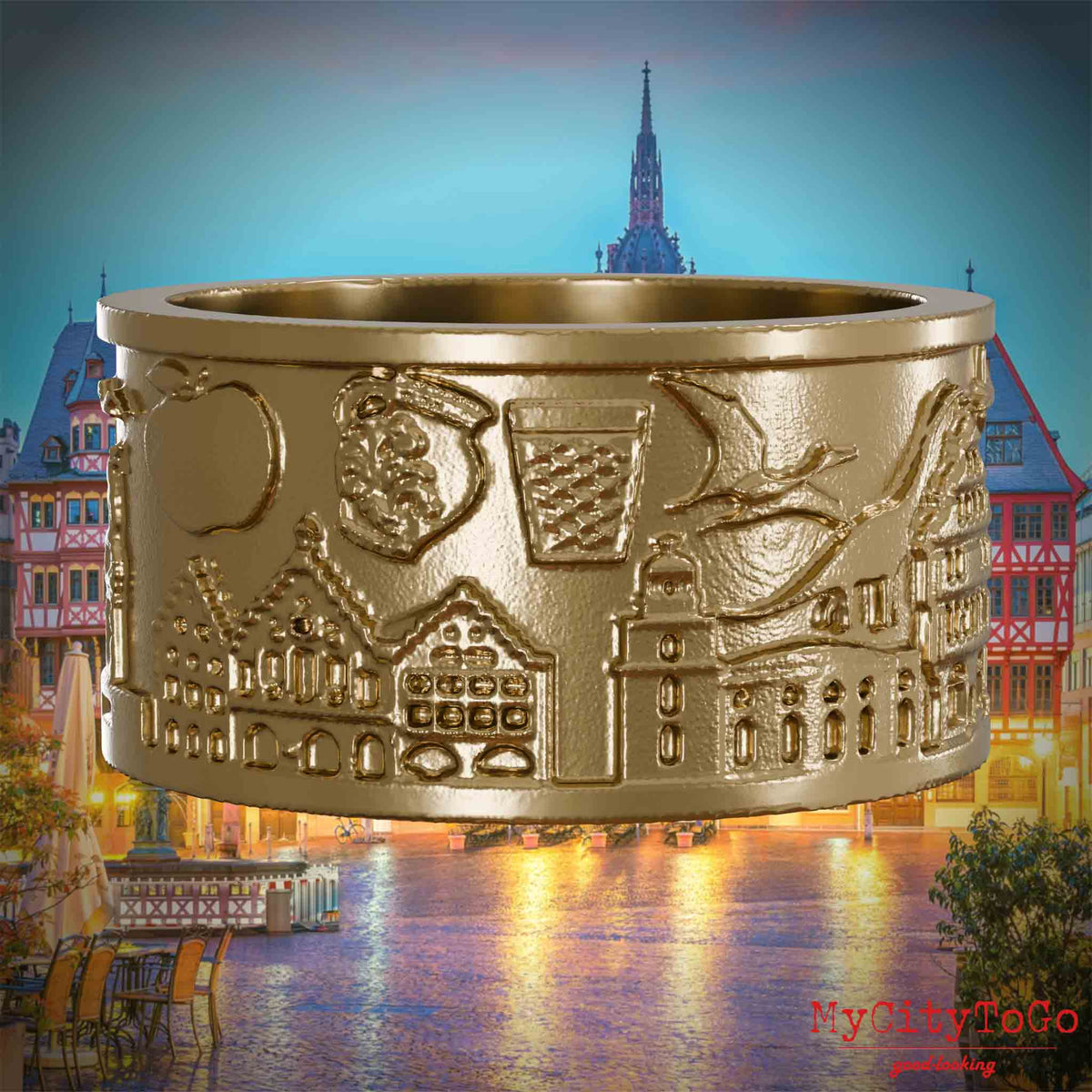 Ring aus vergoldetem Edelstahl mit Reliefs bekannter Sehenswürdigkeiten der Stadt Frankfurt. Den Hintergrund bildet eine Ansicht der Stadt Frankfurt.