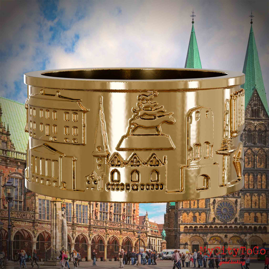 Vergoldeter Ring mit Reliefs bekannter Sehenswürdigkeiten der Stadt Bremen. Den Hintergrund bildet eine Ansicht der Stadt Bremen.