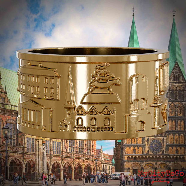 Vergoldeter Ring mit Reliefs bekannter Sehenswürdigkeiten der Stadt Bremen. Den Hintergrund bildet eine Ansicht der Stadt Bremen.