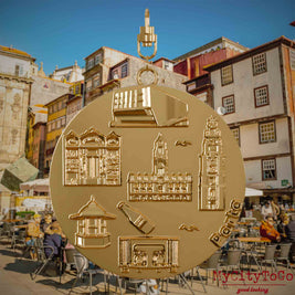 Halskette mit Drehwirbel und Vorderseite eines vergoldeten Schmuckanhängers, auf dem Reliefs bekannter Sehenswürdigkeiten der Stadt Porto abgebildet sind. Den Hintergrund bildet eine Ansicht der Stadt Porto.
