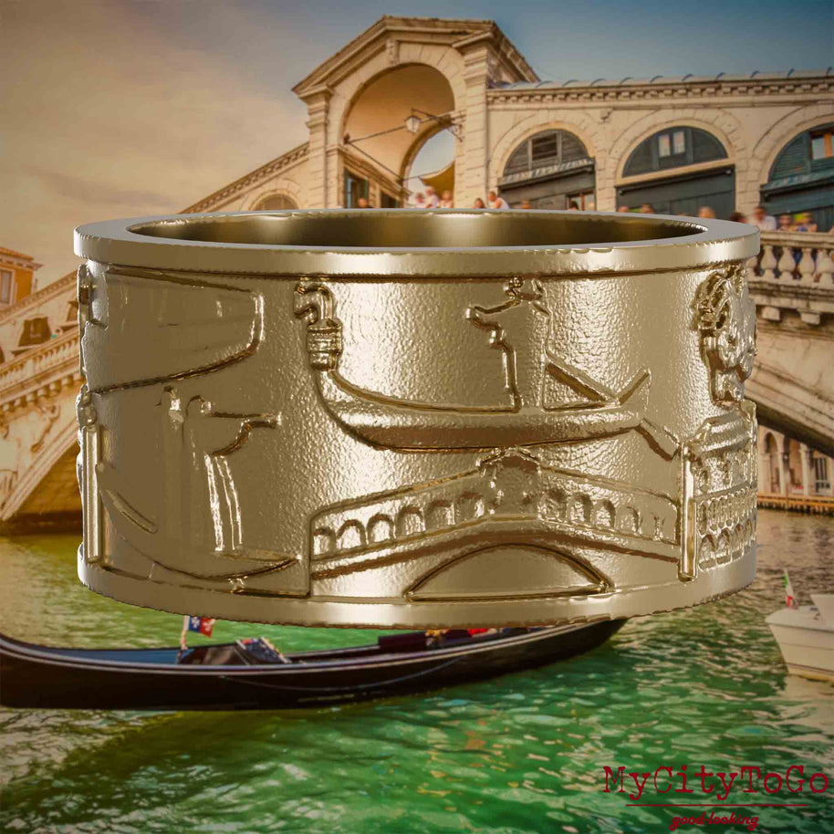 Ring aus vergoldetem Edelstahl mit Reliefs bekannter Sehenswürdigkeiten der Stadt Venedig. Den Hintergrund bildet eine Ansicht der Stadt Venedig.