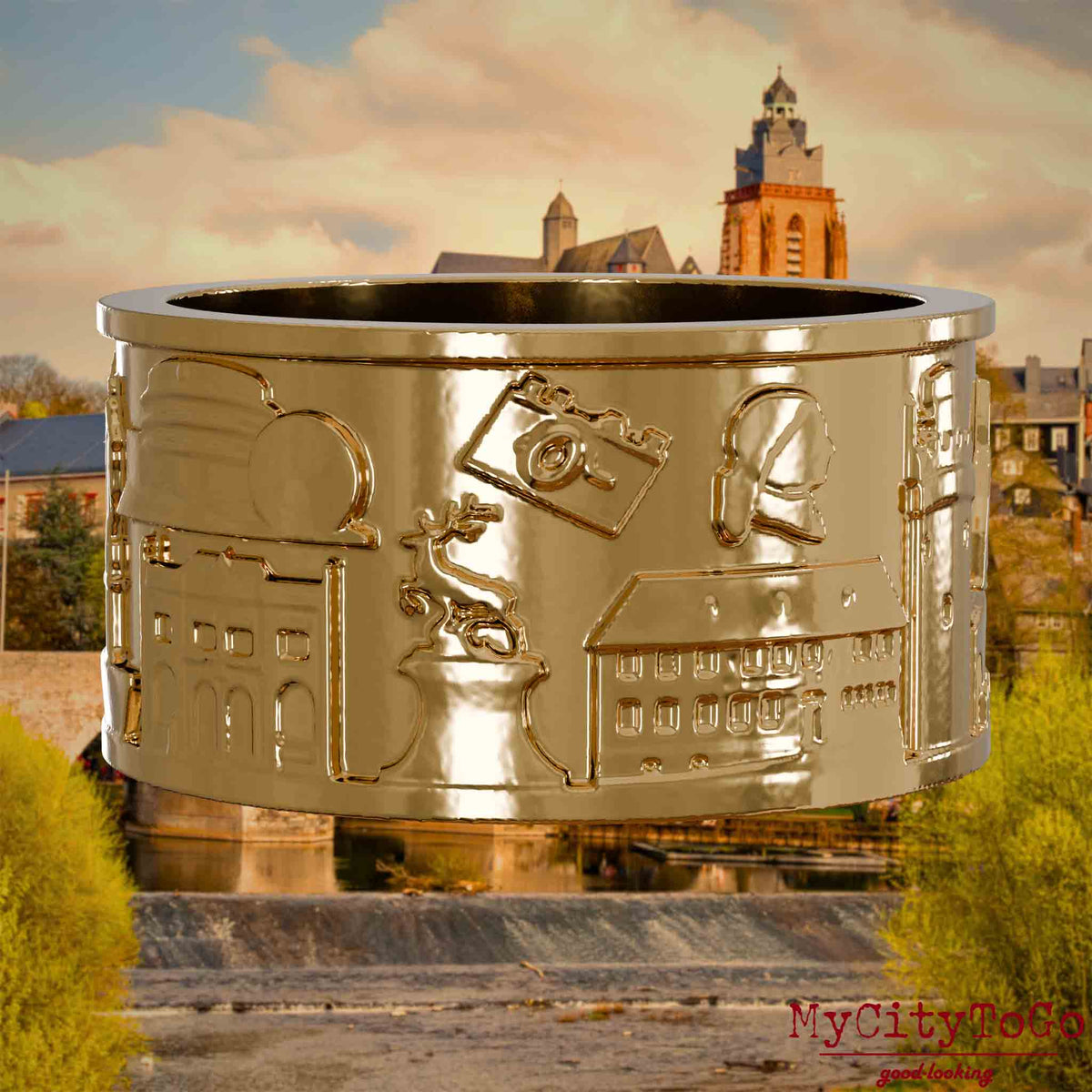 Vergoldeter Ring mit Reliefs bekannter Sehenswürdigkeiten der Stadt Wetzlar. Den Hintergrund bildet eine Ansicht der Stadt Wetzlar.