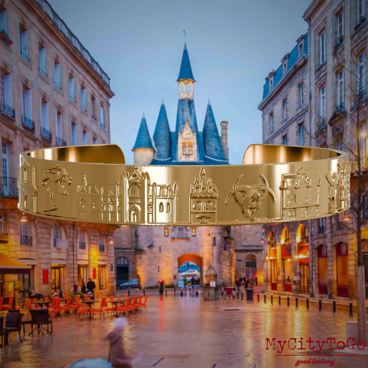 Vergoldeter Armreif mit Reliefs bekannter Sehenswürdigkeiten der Stadt Bordeaux. Den Hintergrund bildet eine Ansicht der Stadt Bordeaux.